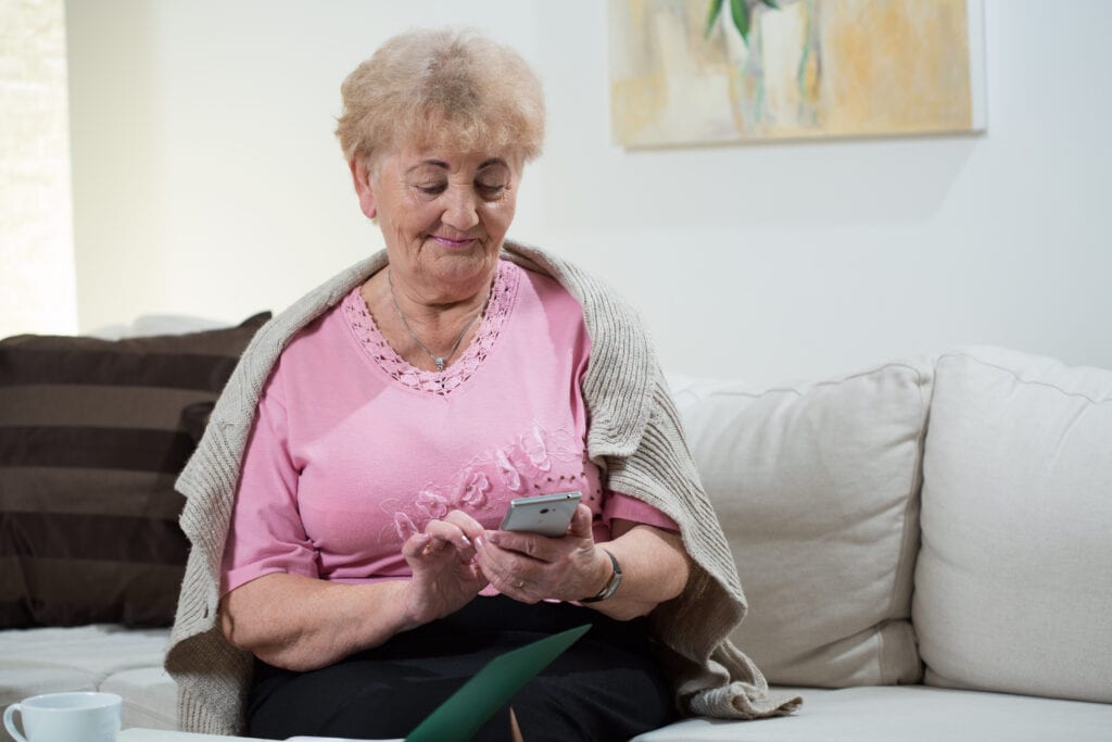 Active and modern elder woman using mobile phone