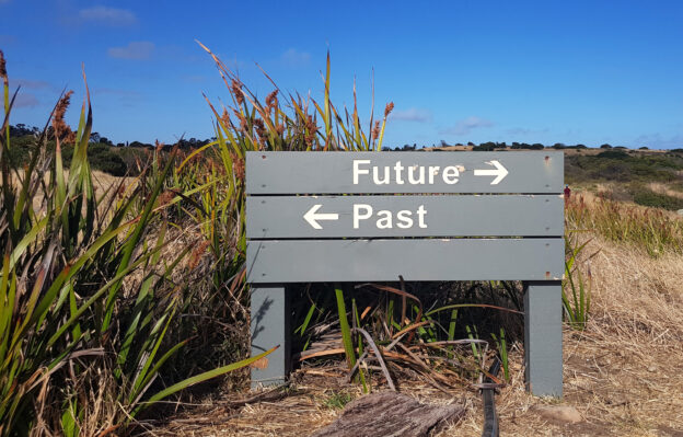 A wooden sign with an arrow pointing left that reads 'past' and an arrow pointing right that reads 'future'